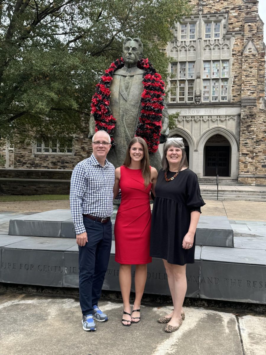 Mrs. Albritton and her family posed in front of a statue in burrow hall at Rhodes College.